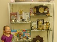 Lone Star Chapter 124 has developed a traveling exhibit of clocks, watches, books and ephemera suitable for exhibits in libraries.  The exhibit is the result of a suggestion from Chris Grim, a Chapter member who volunteers at his daughtrer Bella's school.  It was there that he got the idea of a horological exhibit for children.  The exhibit is named for Bella.  Bella's grandparents Hugh and Evelyn Slough put the exhibit together.  This photo shows Bella in front of the exhibit in the Duncanville, TX Public Library.