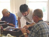 Larry Grubb is cleaning up the tablet after shellac was applied. Instructor Craig Burgess assists Joe Plunket with a few pointers.