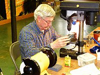 Earl Wilson is drilling a hole in an arbor for the lifting lever he is making.