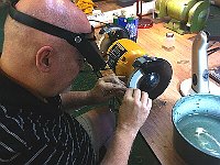 Kelsey Downum is grinding a steel cutting tool.