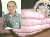 Bob Cochran holds a wheel from a SWCC movement. Yes, the clock winds every 5 minutes; thus the reason for the 12 teeth on this wheel. We didn't think it was proper to only show Bob's hand, so we overlaid the photo with a photo of his face!