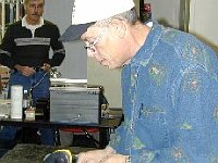 Mike Coker is using a belt sander to modify files for use in barrel tooth replacement.