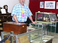 Here Bill is standing behind the counter in his shop awaiting customers.  It looks like Bill may also have some clocks and watches for sale.